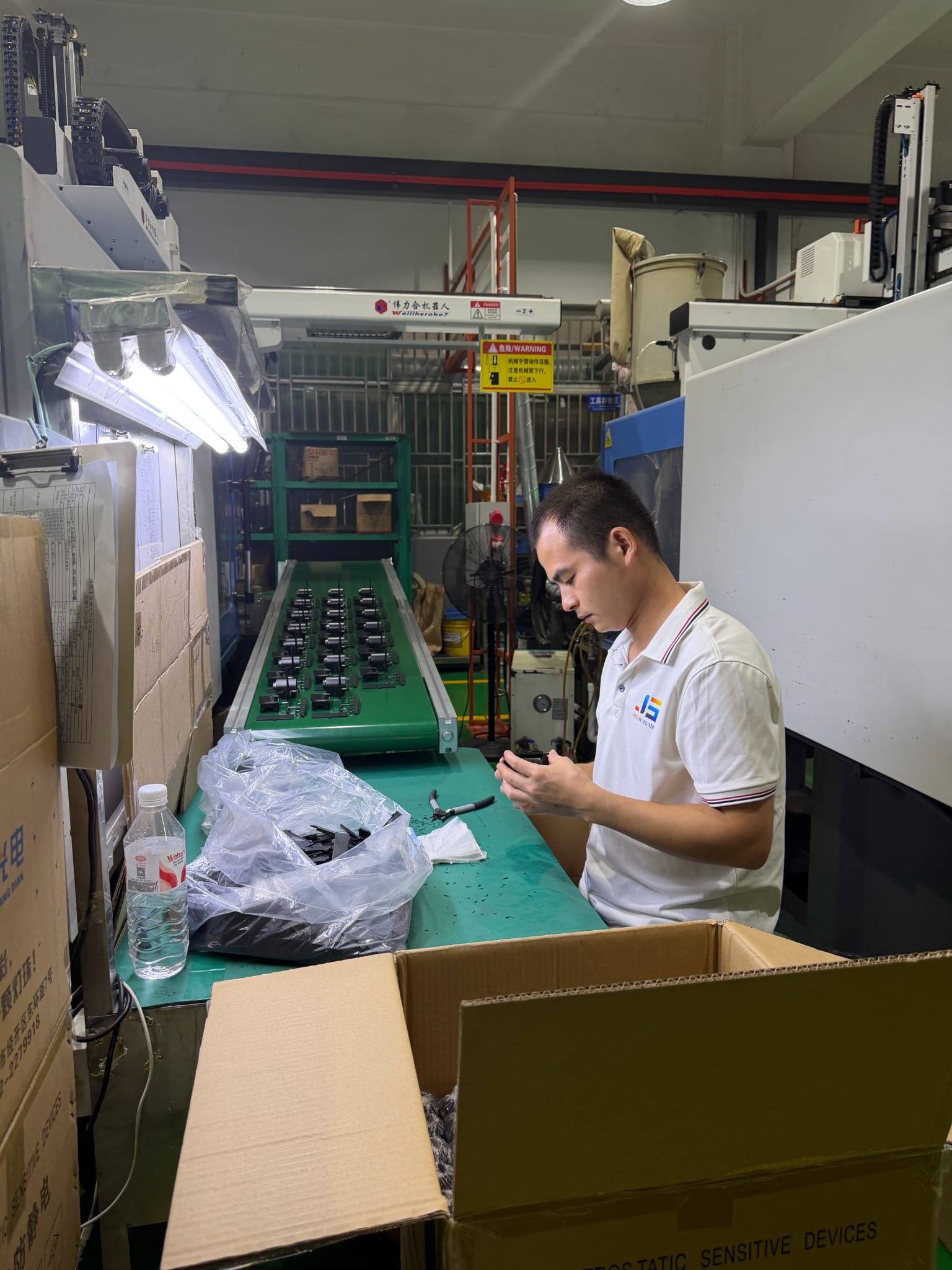 JSG operator inspecting molded miniature pump components during production