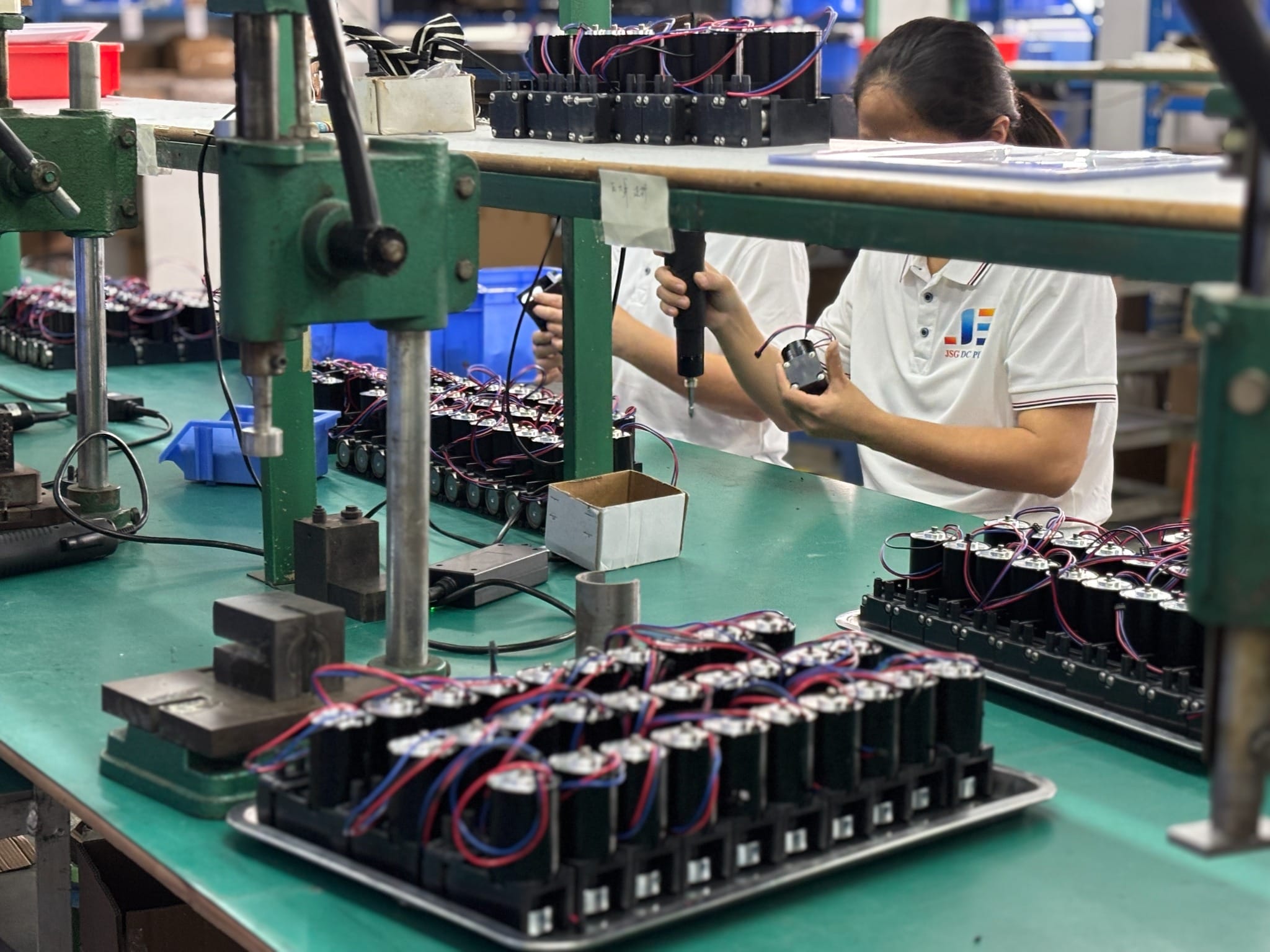 JSG worker assembling miniature pumps during in-process production