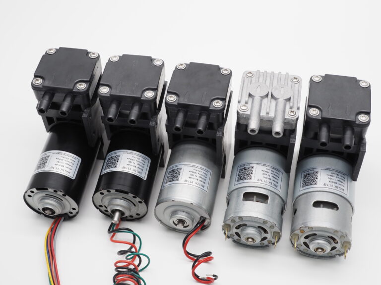 Five miniature pumps arranged side by side with different visible motor and pump-head configurations